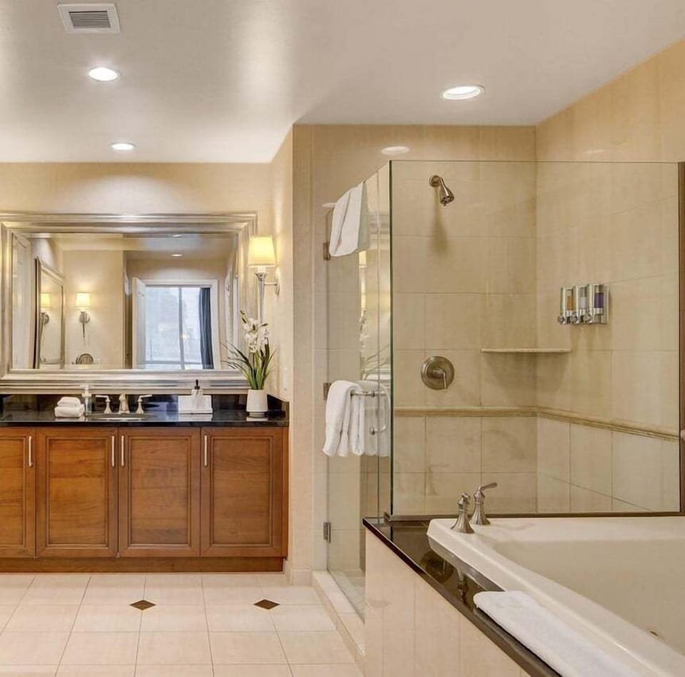 Primary bedroom bath with 2 vanities, shower, jetted tub & private bathroom.