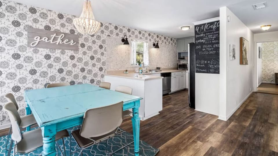Your open kitchen flows into a bright dining area with turquoise table and charming chandelier.