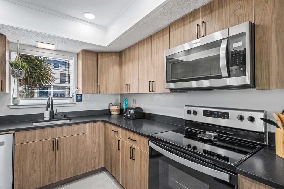 Your fully equipped kitchen features modern appliances and warm wood cabinetry, perfect for preparing meals during your stay.