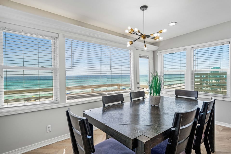 Gather around this elegant dining table while soaking in breathtaking ocean views through floor-to-ceiling windows.