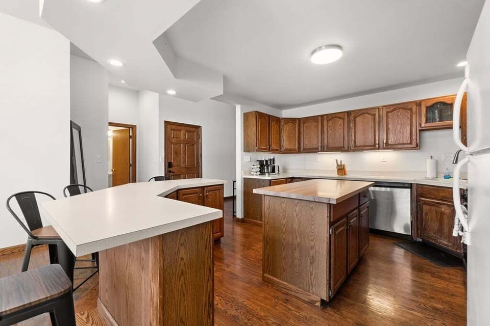 Full kitchen with bar seating for six — center island, dishwasher, and dedicated coffee station.
