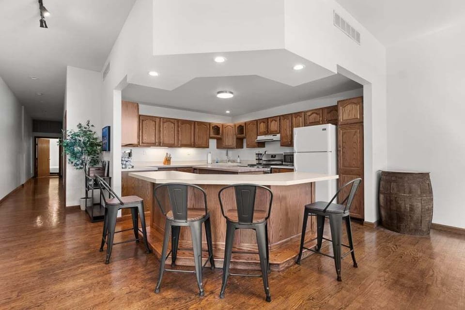 Open layout: kitchen flows through the arched passthrough to the pool room and lake-view living space.