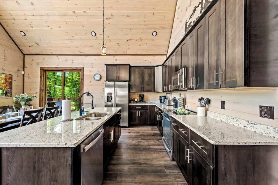 Gourmet kitchen with granite countertops, stainless appliances, and rich dark wood cabinetry.