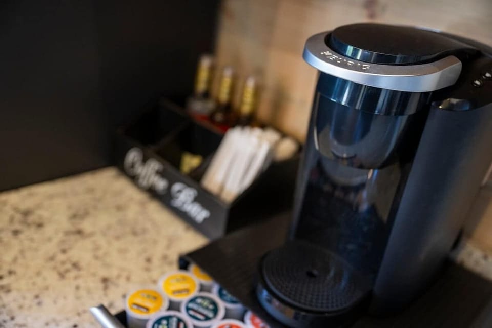 Convenient coffee bar setup with Keurig, assorted pods, and flavored syrups for a cozy start to the day.