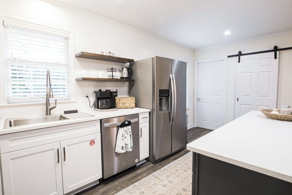 Kitchen stocked with Keurig coffee maker and tea pot along with coffee/tea