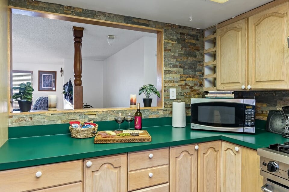 Pour the wine and pass the charcuterie straight to the living room! The kitchen pass-through keeps you connected to the group, while the stacked stone surround, built-in wine rack, and generous counter space keep things seamless.