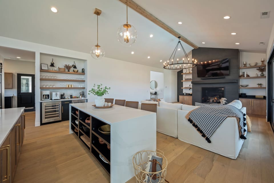 Large, open concept main floor with living room, double island kitchen, dining room and coffee/wine bar