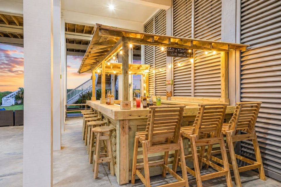 Covered tiki-style outdoor bar and dining area with bar seating, ideal for entertaining, relaxing, and enjoying coastal breezes at this Crystal Beach rental.