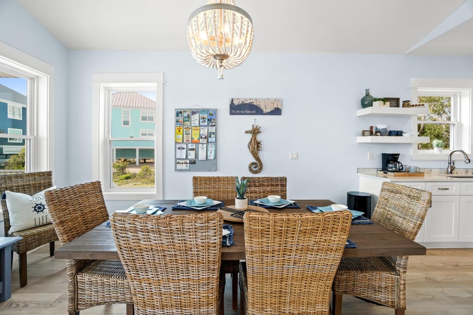 Gather around your elegant dining table with coastal views streaming through bright windows, creating the perfect setting for memorable meals.