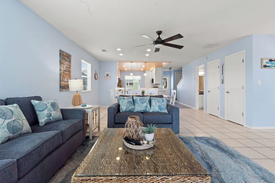 Relax in your spacious open living area where coastal blues and comfortable seating create the perfect spot to unwind after your adventures.