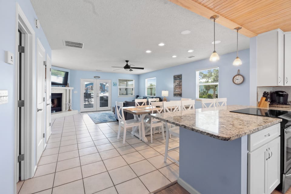 Gather around your spacious kitchen island with granite countertops and white cabinetry, perfect for morning coffee or evening meals together.
