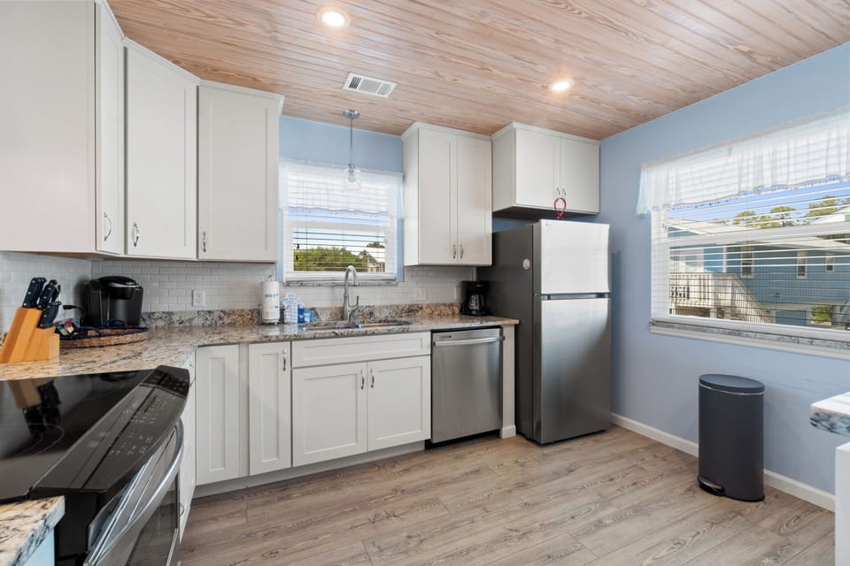 Cook your favorite meals in this modern kitchen with granite counters, stainless appliances, and peaceful blue walls.