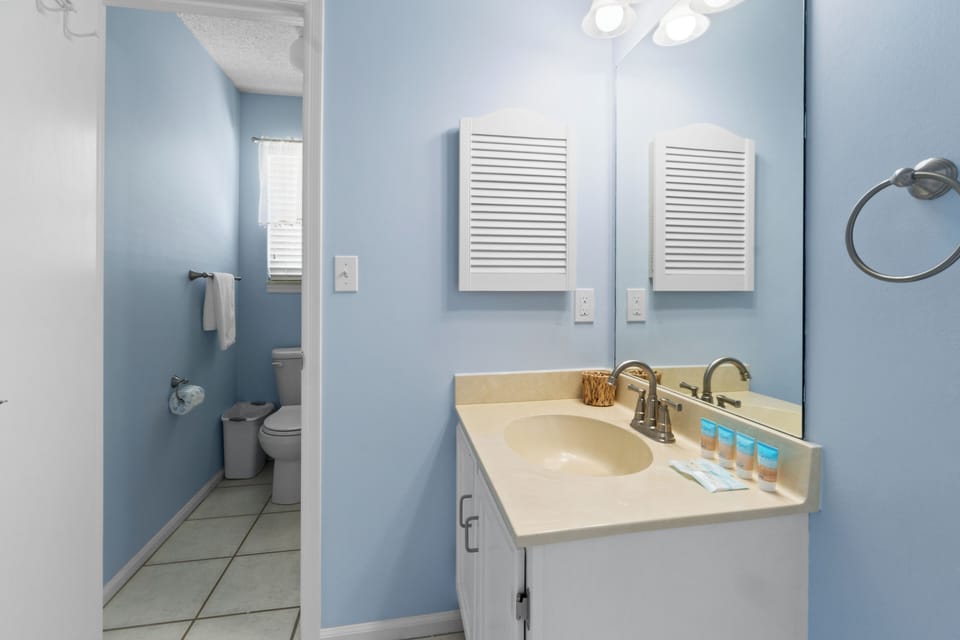 Step into your serene bathroom with soothing blue walls and modern amenities, featuring a spacious vanity for your morning routine.