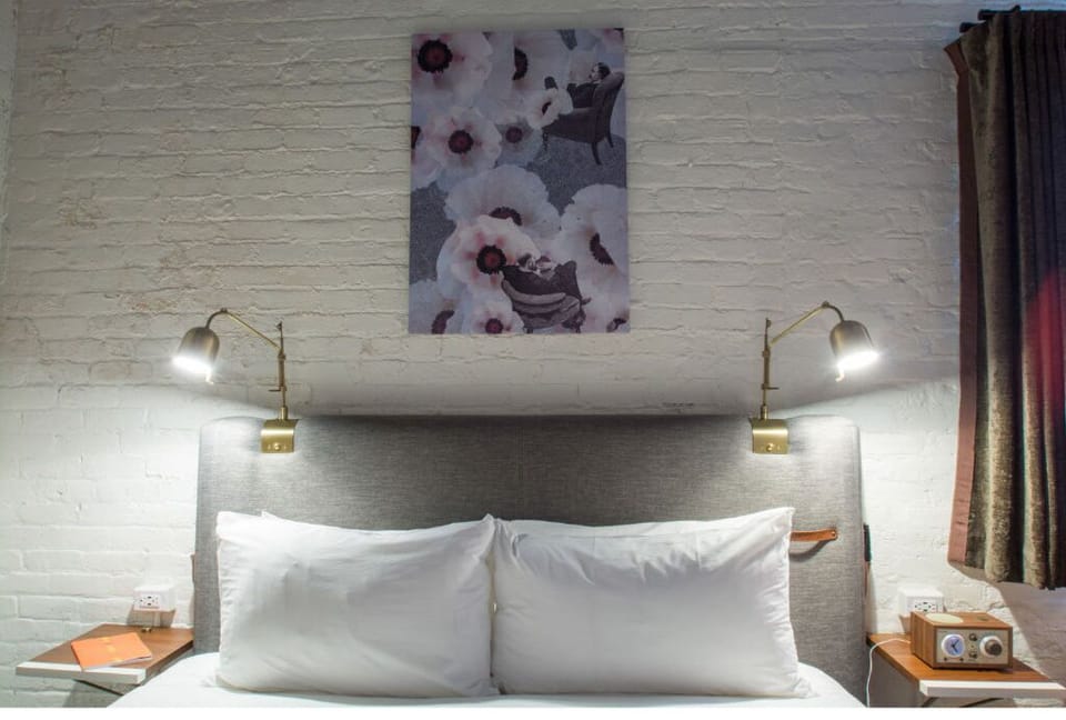 Tranquil bedroom with white brick backdrop and purple floral art