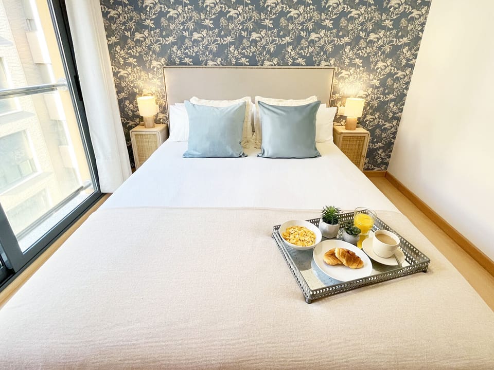 Designer bedroom characterized by an exclusive wallpaper accent wall and a large floor-to-ceiling window. Space that guarantees maximum natural light and a premium and serene ambiance.