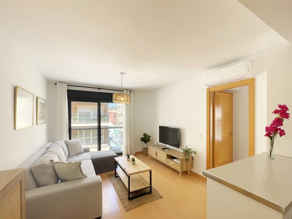 Cozy living room defined by a highly comfortable modular sofa and a decor that balances contemporary design with artistic details. The space visually connects with the kitchen.