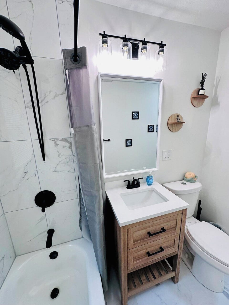 Freshly renovated bathroom with tile walls and floors. Complementary shampoo, conditioner, and body wash.