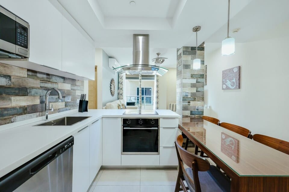 Fully equipped kitchen featuring modern appliances, cookware, essentials, and ample space for meal preparation.