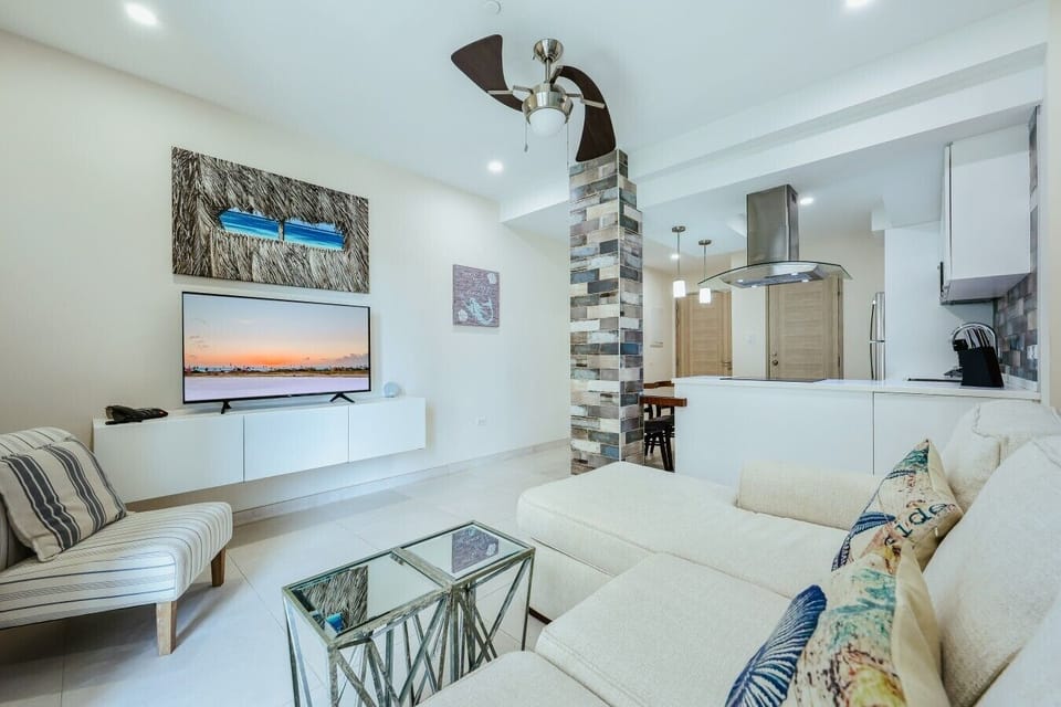 Cozy living room with comfortable seating, smart TV, natural light, and inviting atmosphere.