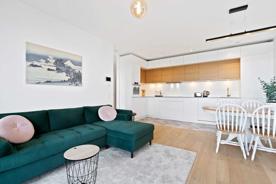 Cozy living space with a comfortable sofa, modern decor, and an open-plan kitchen and dining area.