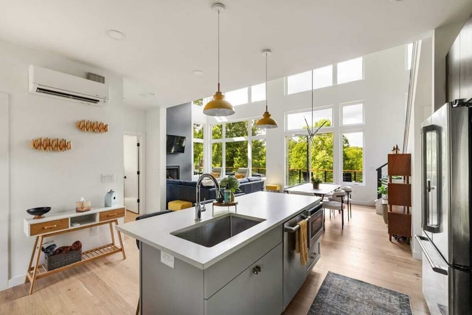 From the kitchen island, enjoy a stunning open layout with sightlines to the dining and living areas, all beneath soaring windows and high ceilings.
