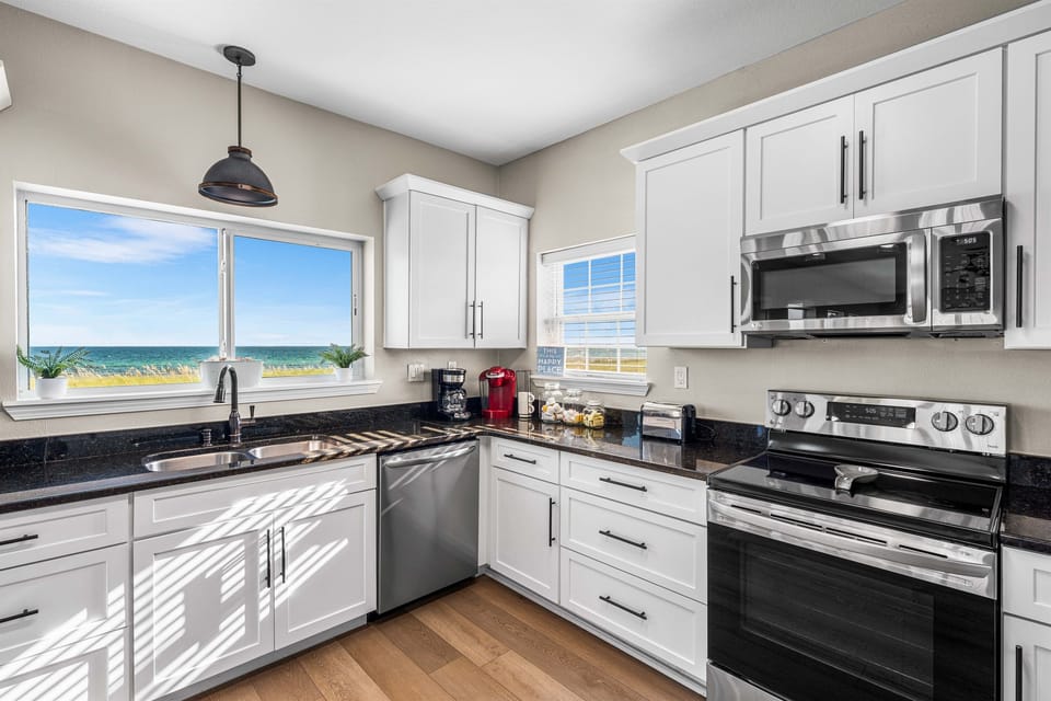 Cook your morning coffee while gazing at stunning ocean views through your kitchen windows. Modern appliances and bright natural light create the perfect culinary retreat.