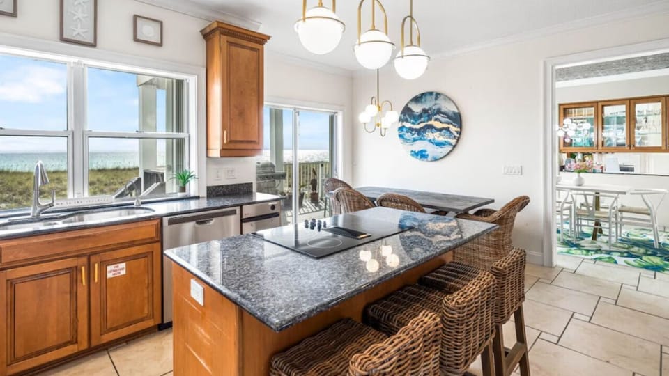 Your gourmet kitchen awaits with granite counters, ocean views, and a breakfast bar perfect for morning coffee with coastal breezes.