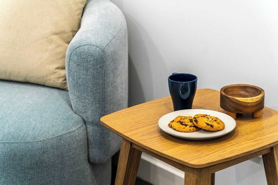 A cosy corner awaits in the bedroom, featuring a small table and couch, perfect for quiet moments of relaxation and reflection.