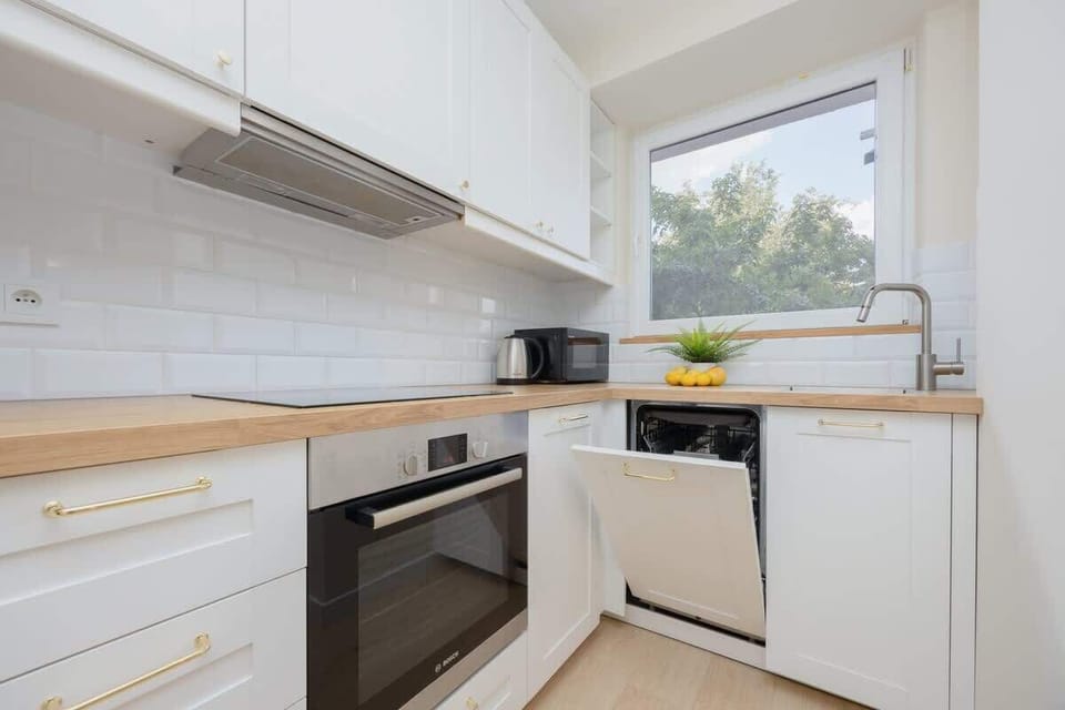 A close-up of a kitchen corner with a microwave, toaster, and a bowl of lemons. Functional and cheerful setup.