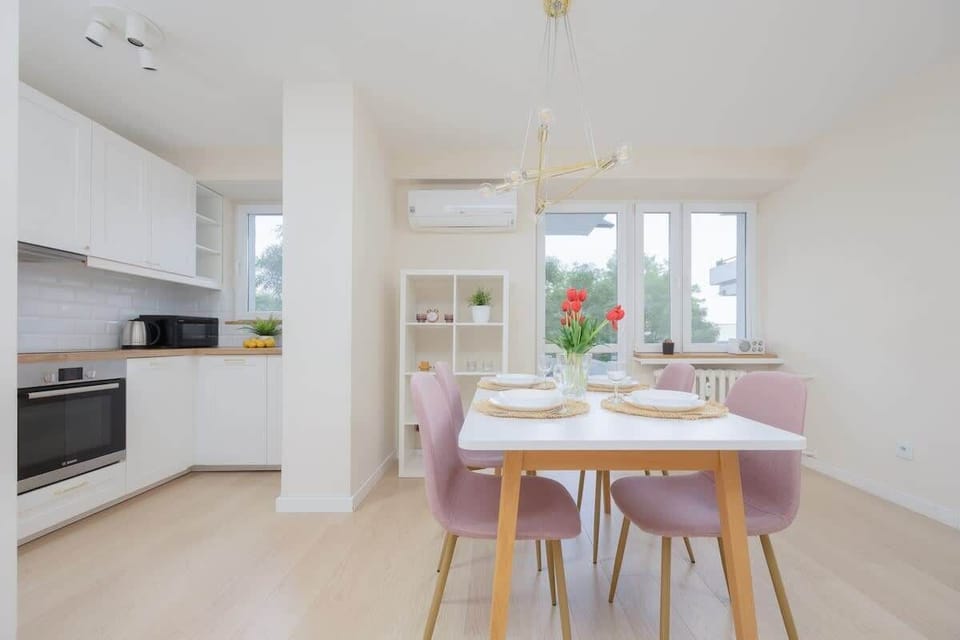 A modern kitchen with ample counter space, next to a dining table. Practical layout for cooking and eating together.