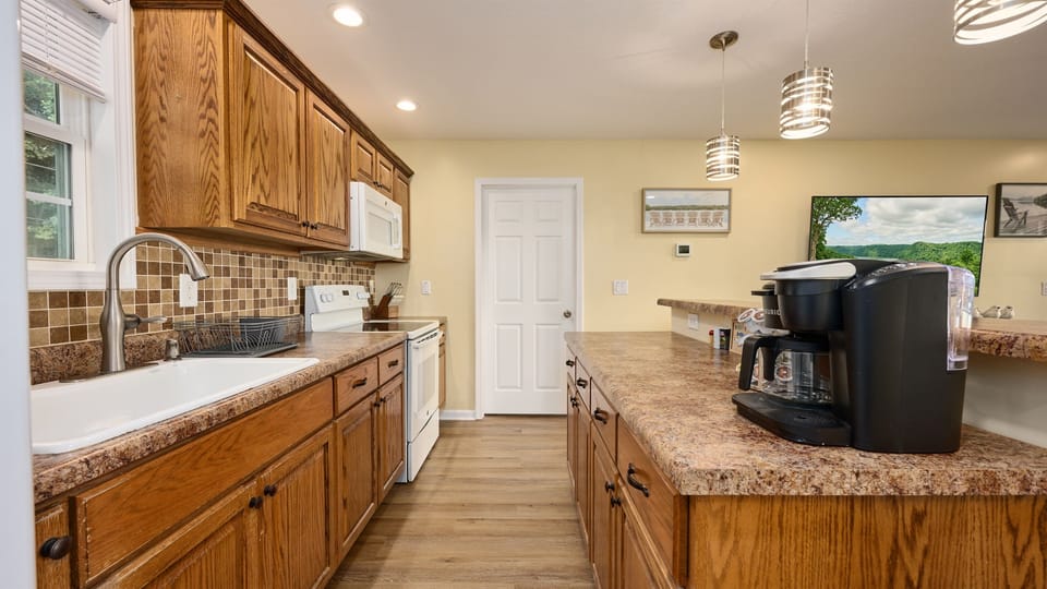 The upper level Kitchen includes a Keurig coffee maker that will brew a whole pot using coffee filters or one cup at time using coffee pods. There is a full size electric range and microwave.