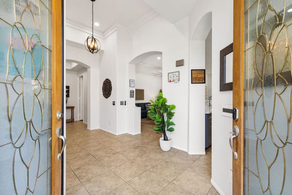 Bright entry hallway w/ decorative glass doors & a warm, welcoming feel.