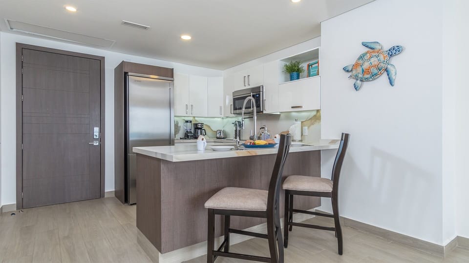 Two seats at the kitchen counter provide the setting.