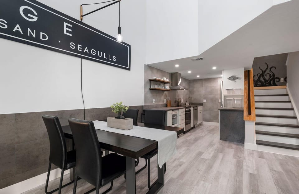 Modern kitchen and dining area with open shelving and staircase detail