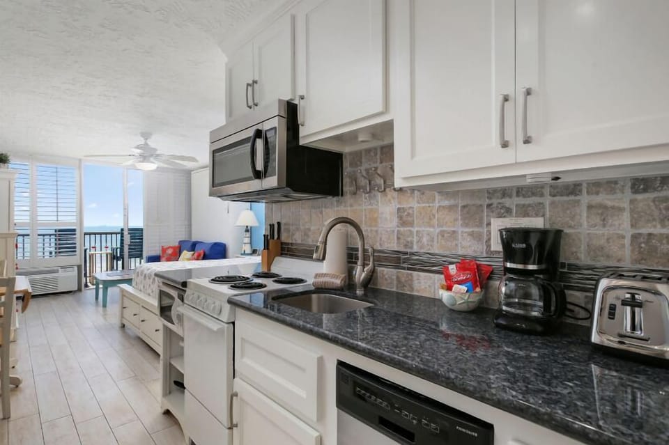 Small and efficient kitchen. Equipped with pots, pans, dishes coffee maker, and toaster.