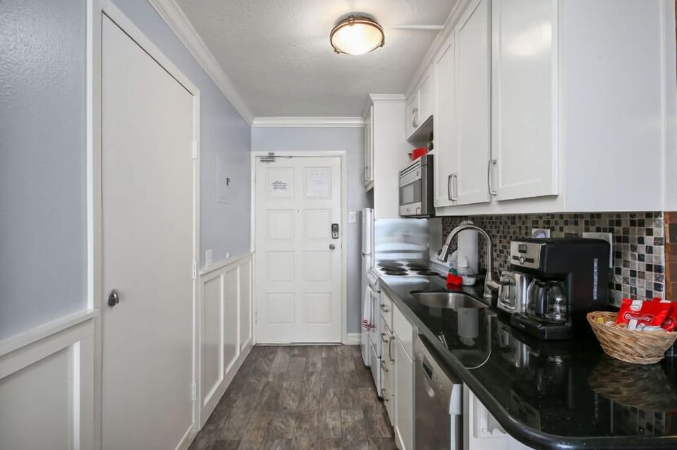 Kitchen is equipped with pots, pans, dishes, coffee maker, and toaster