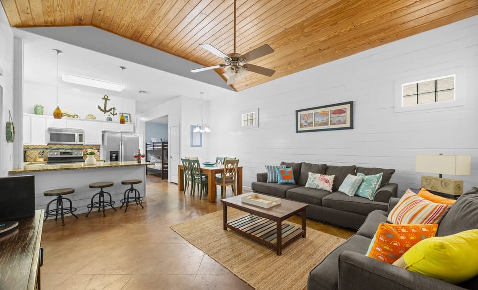 Living Room — Sectional Sofa with Colorful Beach Pillows & Open Kitchen