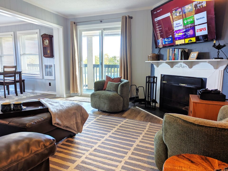 Living room with Sofa bed, wood burning fireplace, smart TV, Xbox, and games.