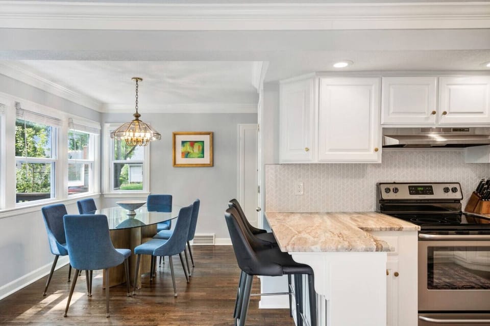 Updated and spacious kitchen with counter seating, situated between the two dining tables.
