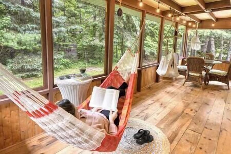 Relax on the screened-in porch of Le Chickadee Chalet with a comfy hammock and serene forest views