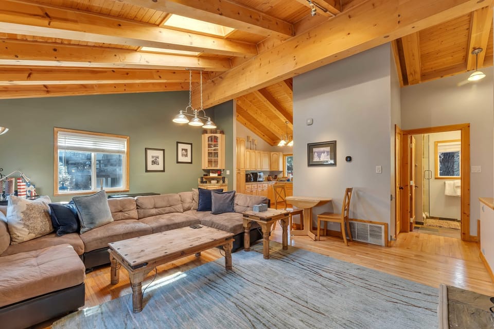 The living room is set up for entertaining with an oversized U shaped couch, wine cooler, wood burning fireplace, and a range of games and movies.