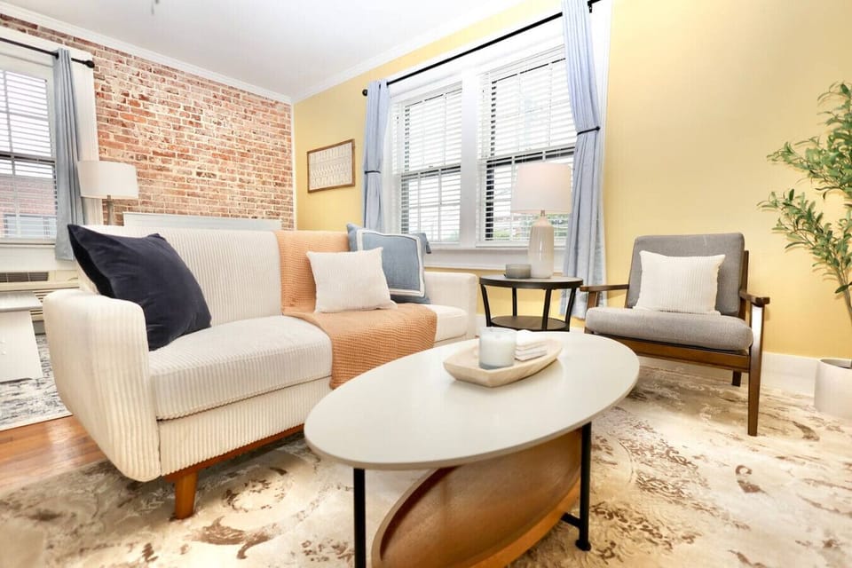 Living Room: Bright brick walls meet modern furnishings for a vibrant retreat in Knoxville!