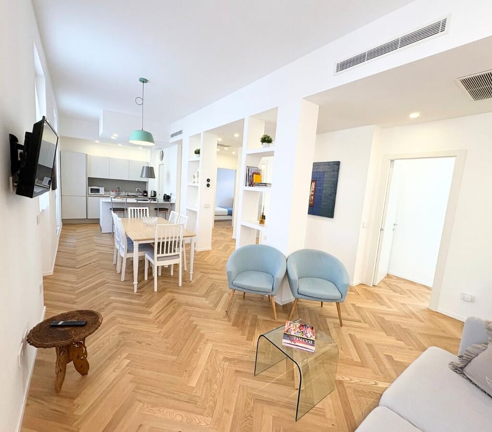 Open-plan space with fully equipped kitchen, TV, A/C, dining and lounge area.