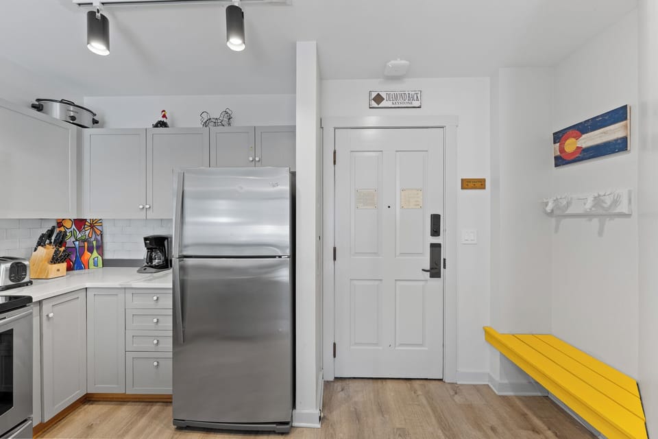 Step into your modern kitchen where sleek stainless steel appliances and bright cabinetry create the perfect space for preparing meals during your stay.