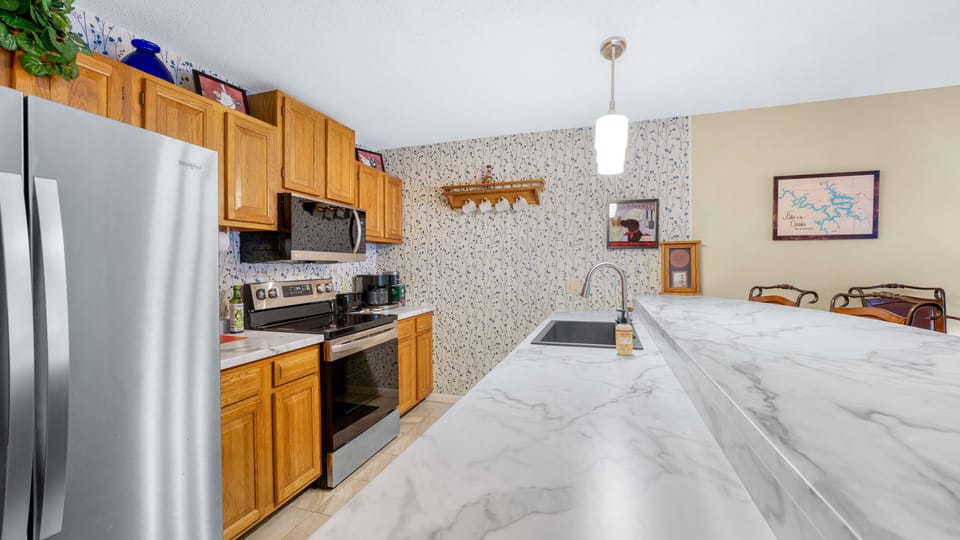 Well Equipt kitchen with stove, refrigerator and dishwasher.