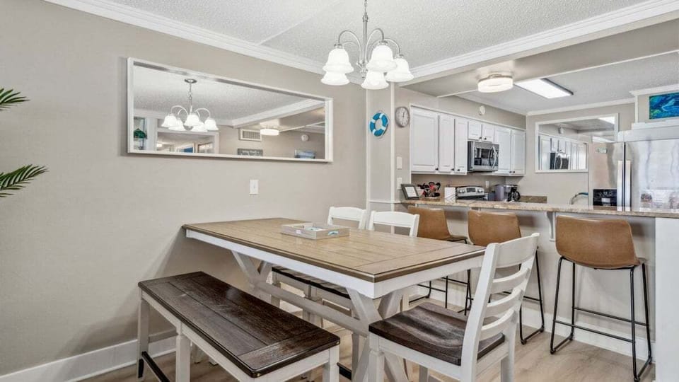 Stylish dining table seating six with cozy bench and breakfast bar stools—perfect for meals, games, or coffee with kitchen views.