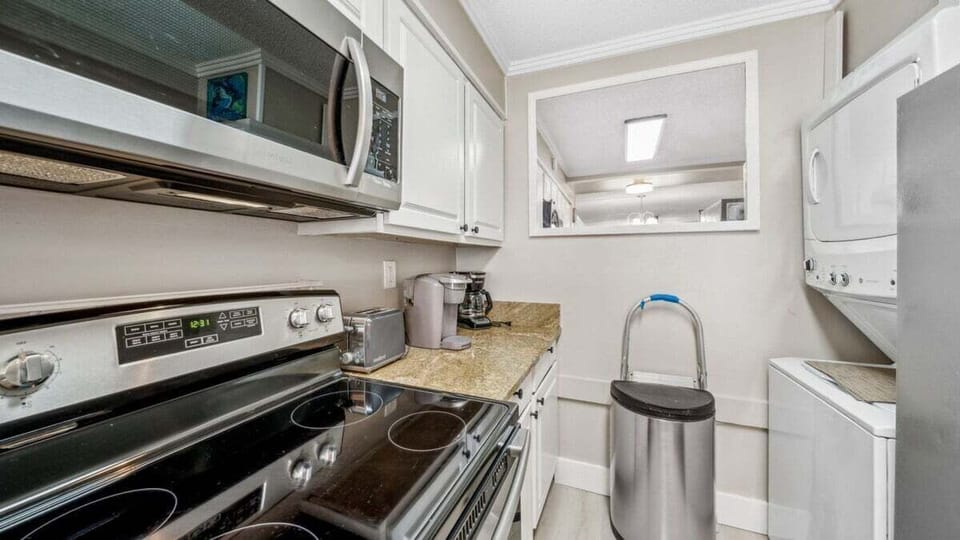 Compact kitchen nook with coffee station, modern appliances, and in-unit washer/dryer—ideal for extended stays.