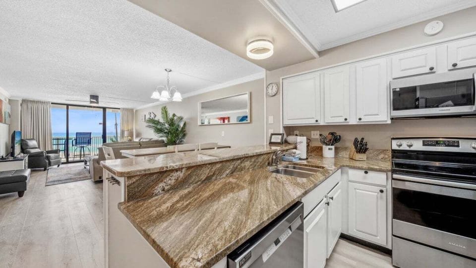 Open kitchen with granite countertops, stainless steel appliances, and Gulf views—perfect for cooking, dining, and relaxing.