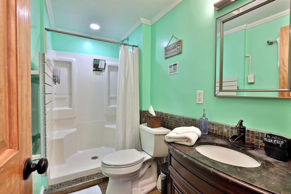 The adjoining bathroom includes a shower with built-in shelves and its own vanity.