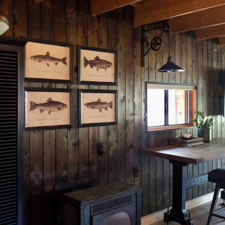 An industrial gathering table with vintage light & art above the gas fireplace.